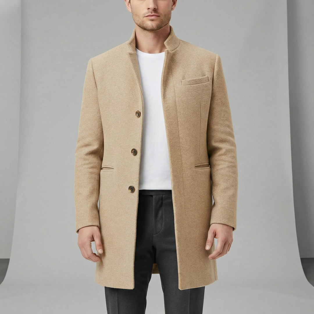 Man bär modern enkelknäppt långkappa. Elegant minimalistisk stil, perfekt för fest och urban herrmode.