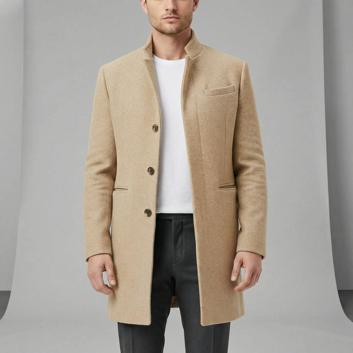 Man bär modern enkelknäppt långkappa. Elegant minimalistisk stil, perfekt för fest och urban herrmode.