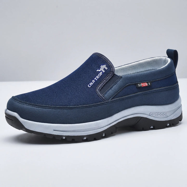 Gråa herr slip-on promenadskor med ergonomisk design och fotvalvsstöd för långa promenader.