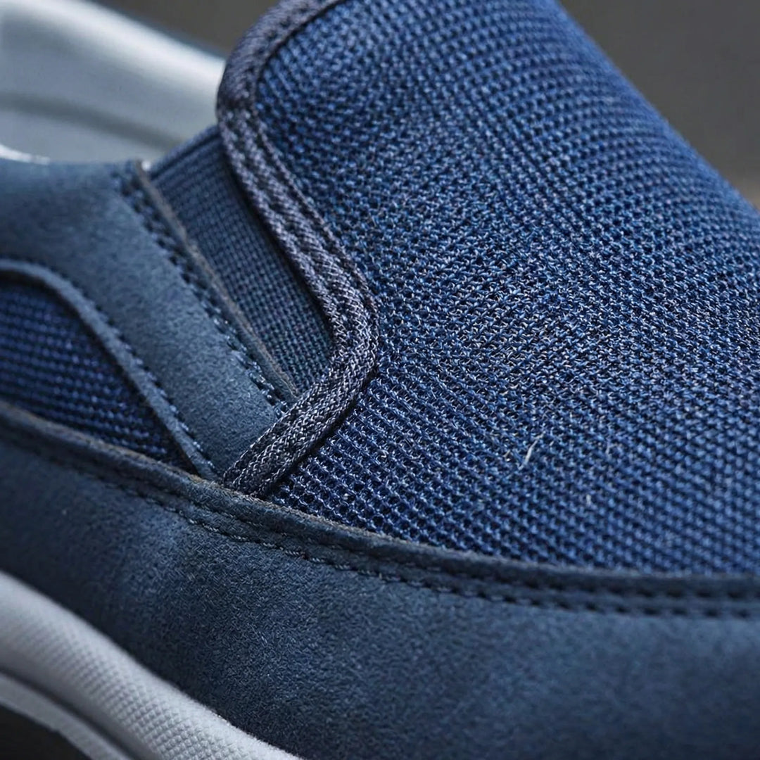 Detaljbild av svarta herr slip-on sneakers med halkfri sula, perfekta för vardagsbruk.