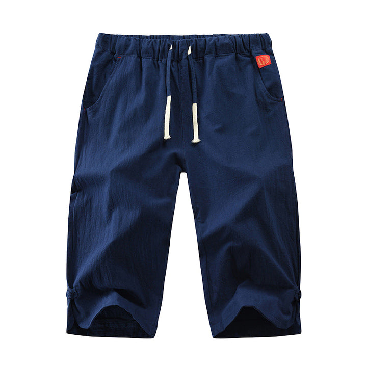"Herrshorts i beige bomull-linne, dragsko och tre fickor, framifrån i soligt väder"
