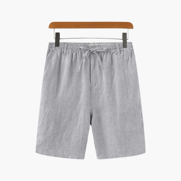 Man bär bekväma blå herrshorts med elastisk midja, dragsko & rymliga fickor. Perfekt för sommaraktiviteter.
