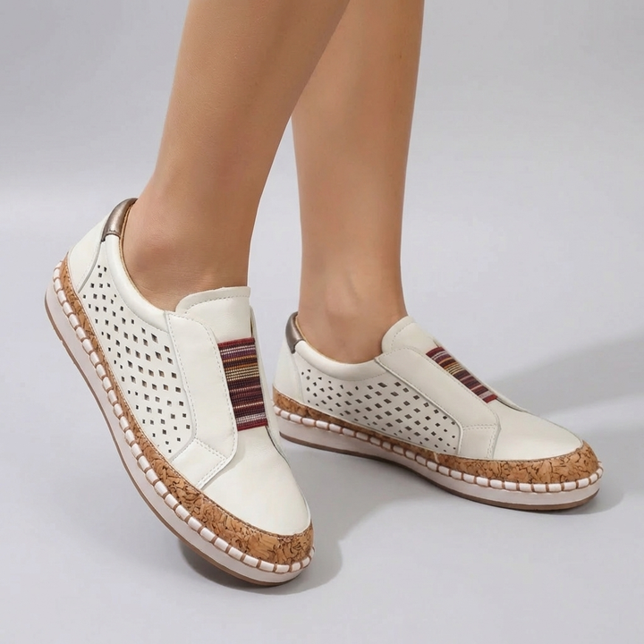 Vita slip-on sneakers med perforerad design och korkliknande mellansula på kvinna