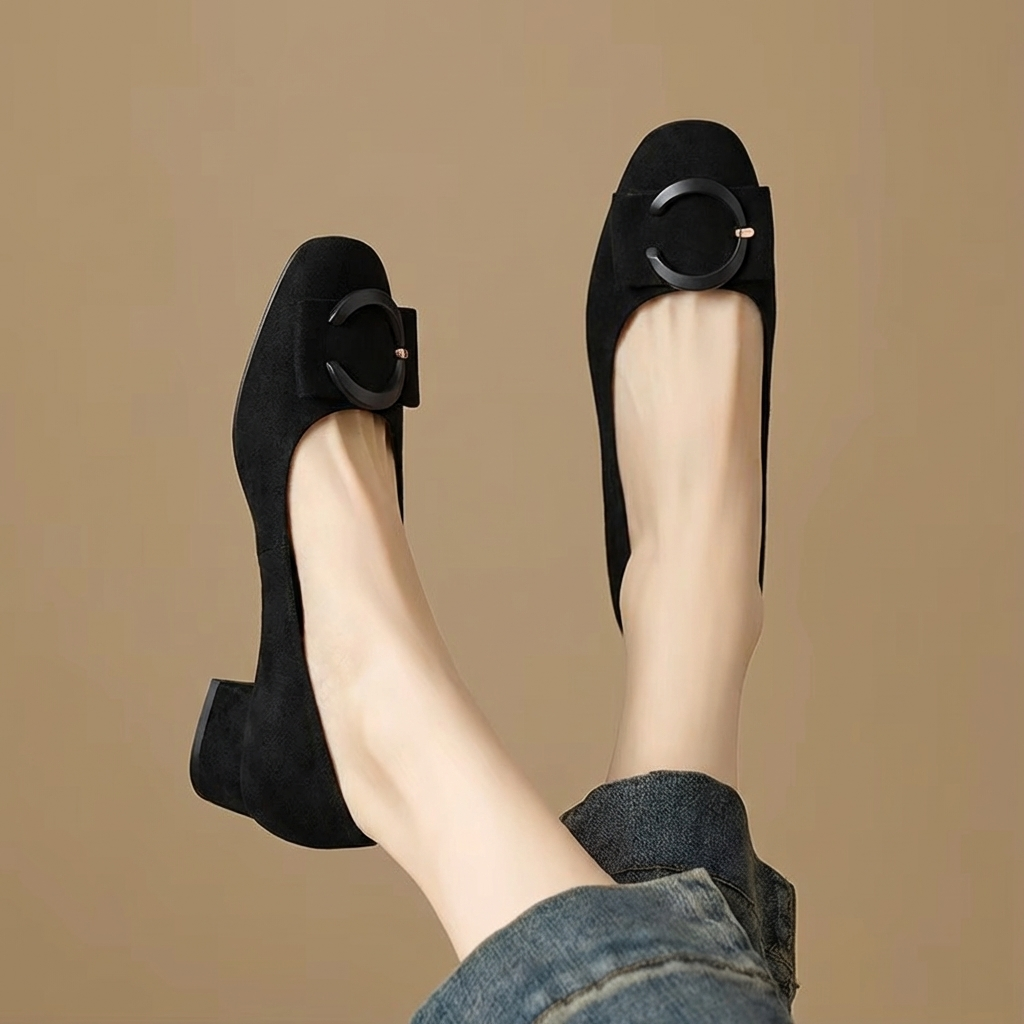 Svarta pumps med låg klack visade i vinkel med jeans
