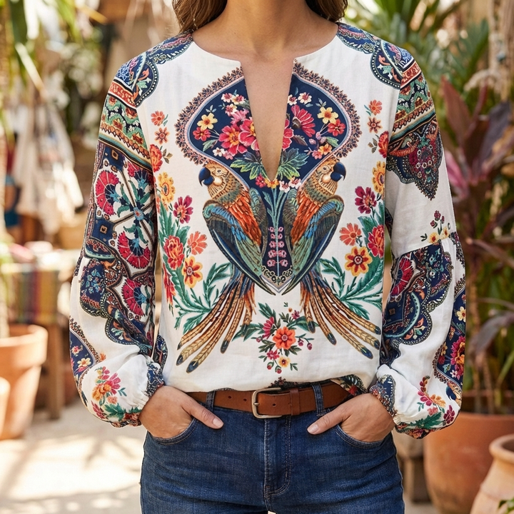 Kvinna i vit blommig blus med papegojmotiv matchad med jeans