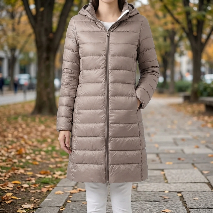 Damjacka med avtagbar huva i beige färg visad utomhus