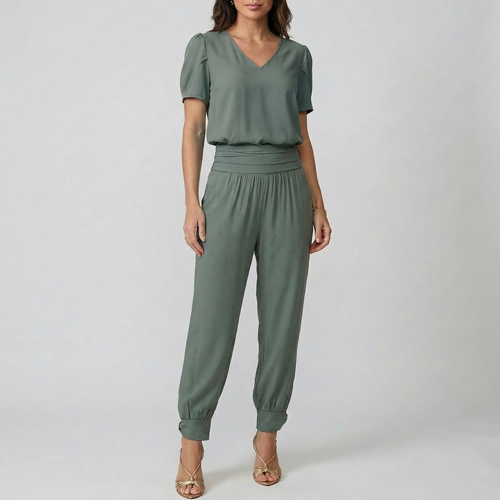 Kvinna i enfärgad grön jumpsuit med resår i midjan
