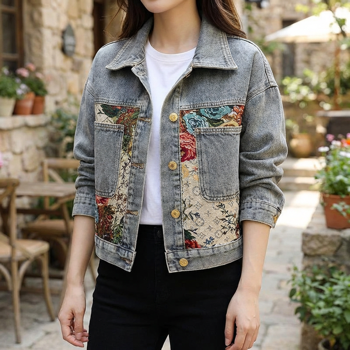 Kvinna som bär en ljusblå denimjacka med blomdetaljer utomhus