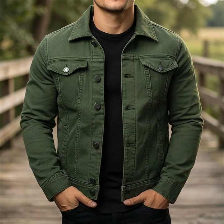 Man bär en armégrön denimjacka utomhus på en bro