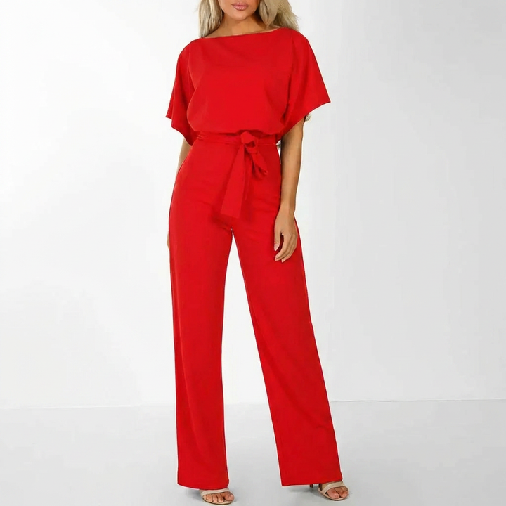 Snygg damjumpsuit med skärp, sedd i profil med fokus på stil och passform