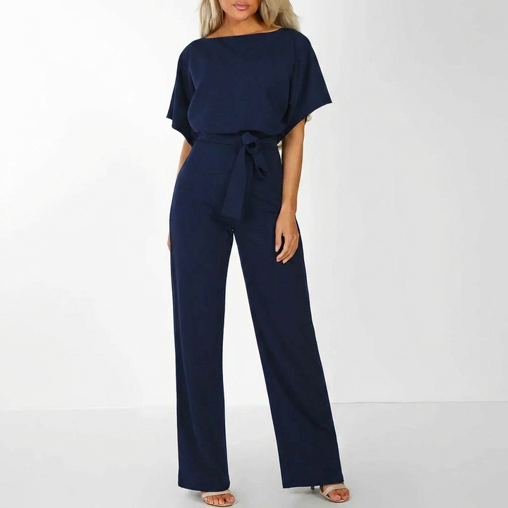Helkroppsbild framifrån av mörkblå elegant jumpsuit på ljus bakgrund