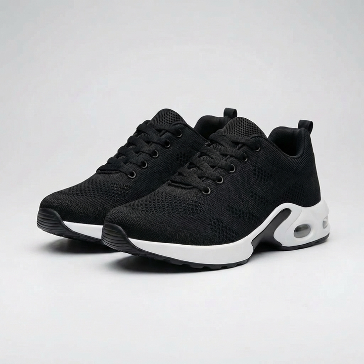 Par svarta luftkuddesneakers mot ljus bakgrund