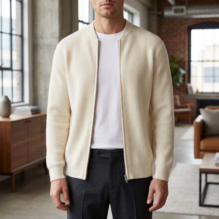 Man i beige stickad cardigan med dragkedja stående inomhus