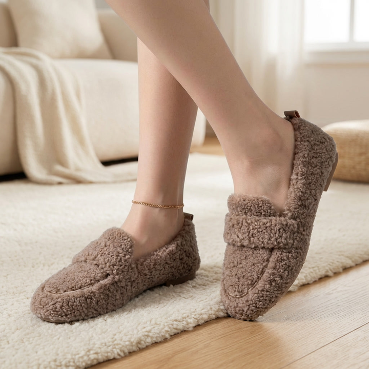 Dam som bär bruna krulliga plysch loafers inomhus