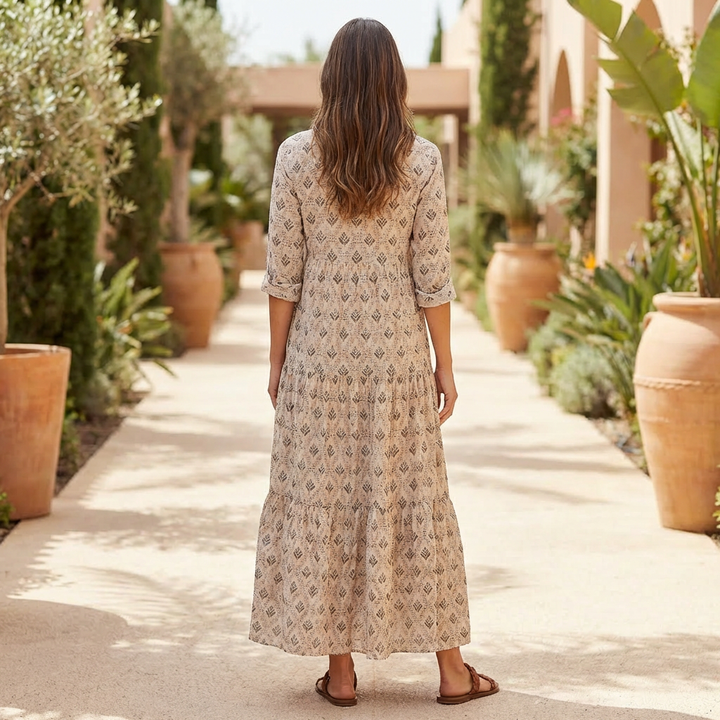 Baksida av kvinna i lång mönstrad boho-klänning utomhus