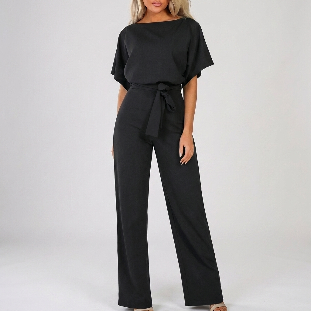 Svart damjumpsuit med kort ärm och knytbälte mot neutral bakgrund