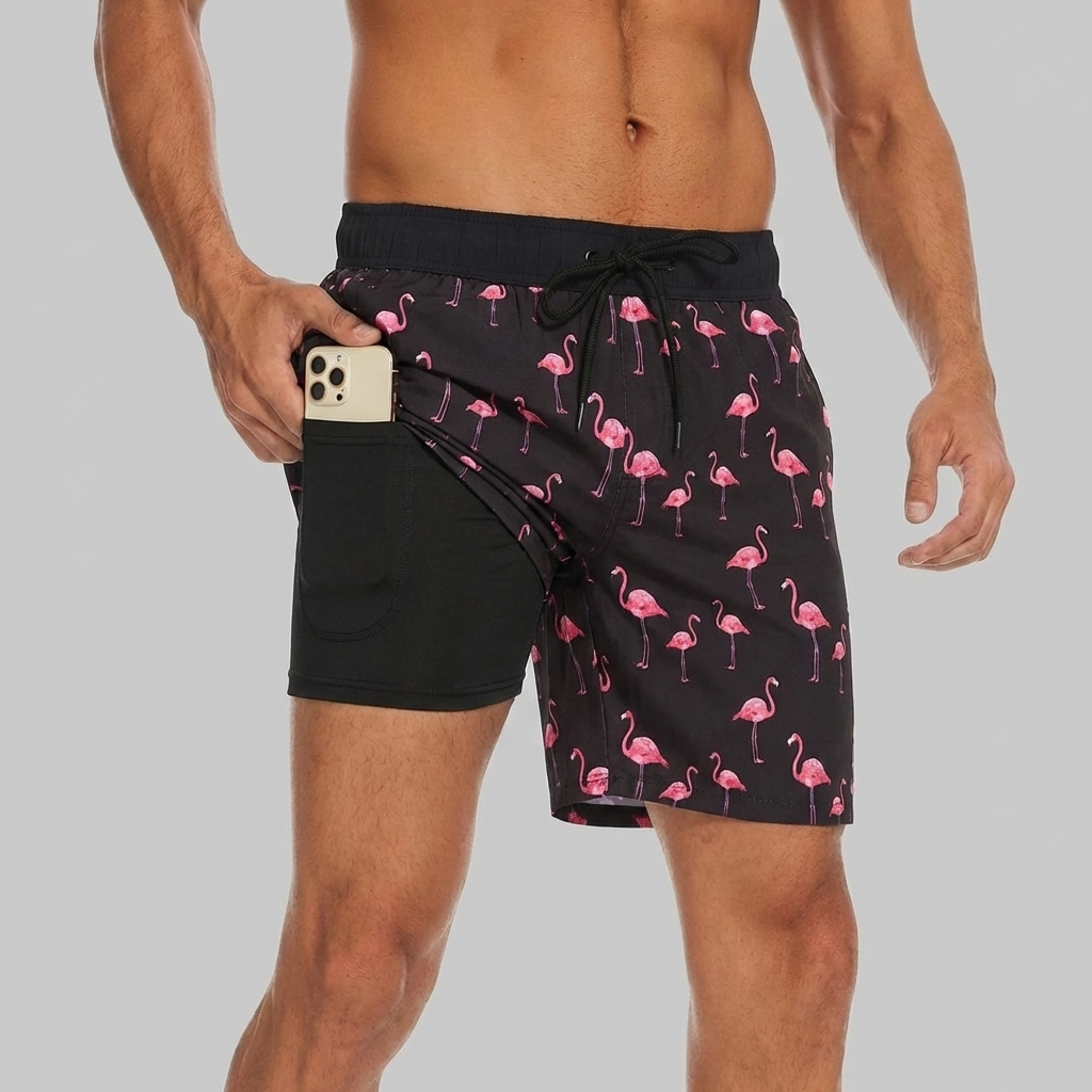 Närbild på herrns simshorts i svart flamingo-mönster med innerfoder