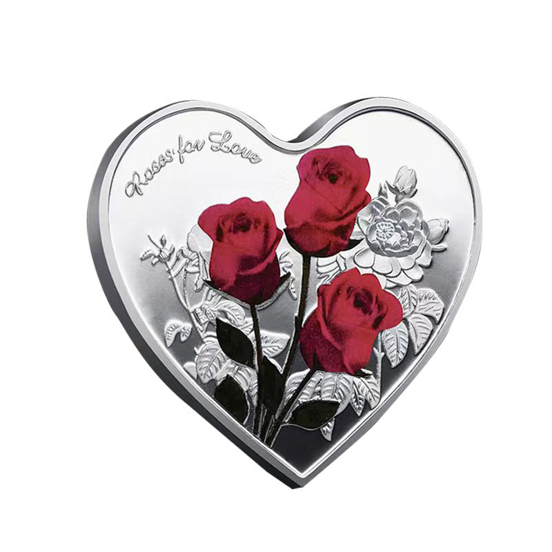 Hjärtformat minnesmynt med rosendesign i silver, kärleksbudskap; perfekt romantisk gåva, dekorativt och hållbart.