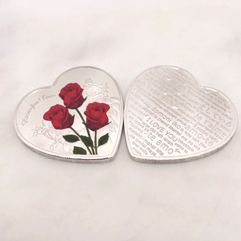 Hjärtformat minnesmynt med rosendesign i silver, kärleksbudskap; perfekt romantisk gåva, dekorativt och hållbart.
