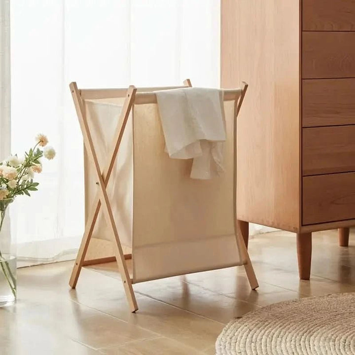 Hopfällbar tvättkorg i massivt trä, elegant och platsbesparande för modern klädförvaring i hemmet.