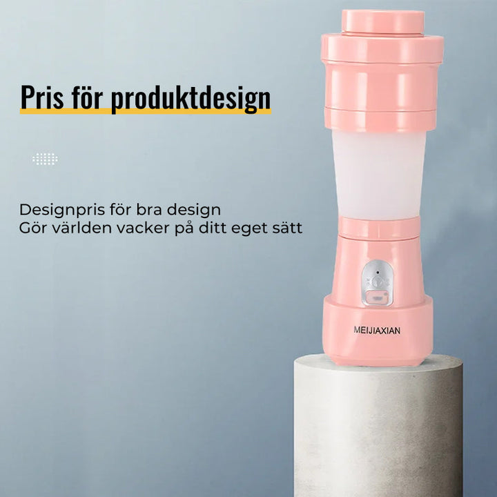 "Hopfällbar mini-juicepresskopp i rosa, kompakt design med rostfritt stålblad, idealisk för hälsosamma drycker på språng."