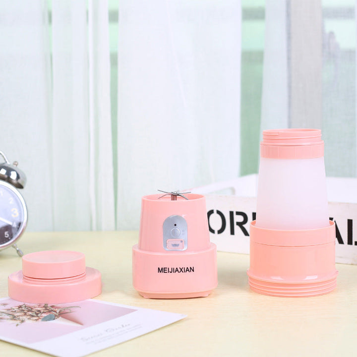 "Hopfällbar mini-juicepresskopp i rosa, kompakt design med rostfritt stålblad, idealisk för hälsosamma drycker på språng."