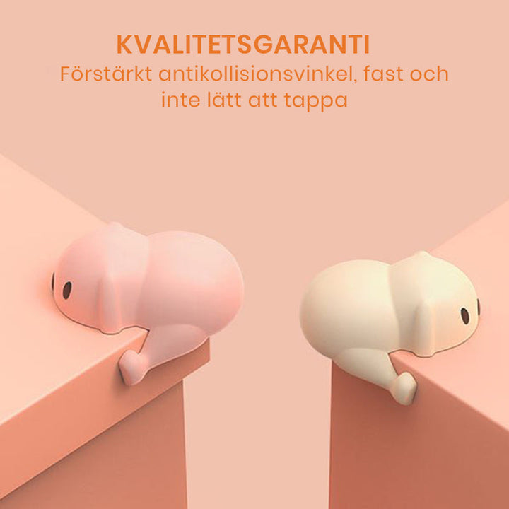 "Hörnskydd i silikon, tecknad design, rosa ton, skyddar barn från skarpa hörn, perfekt för soffbord och stolar."