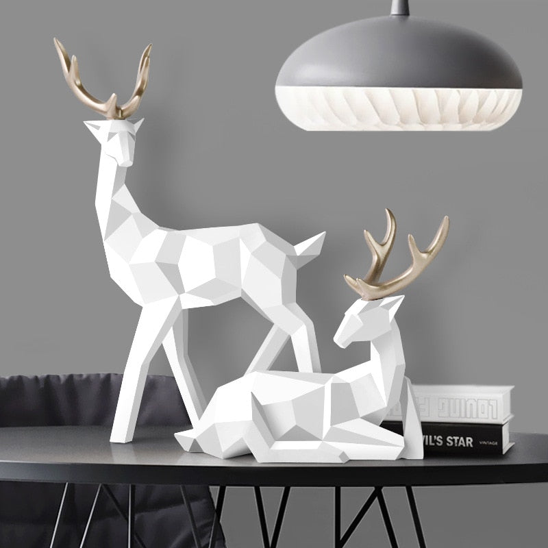 Vit hjortpar skulptur på ett modernt bord under en snygg taklampa