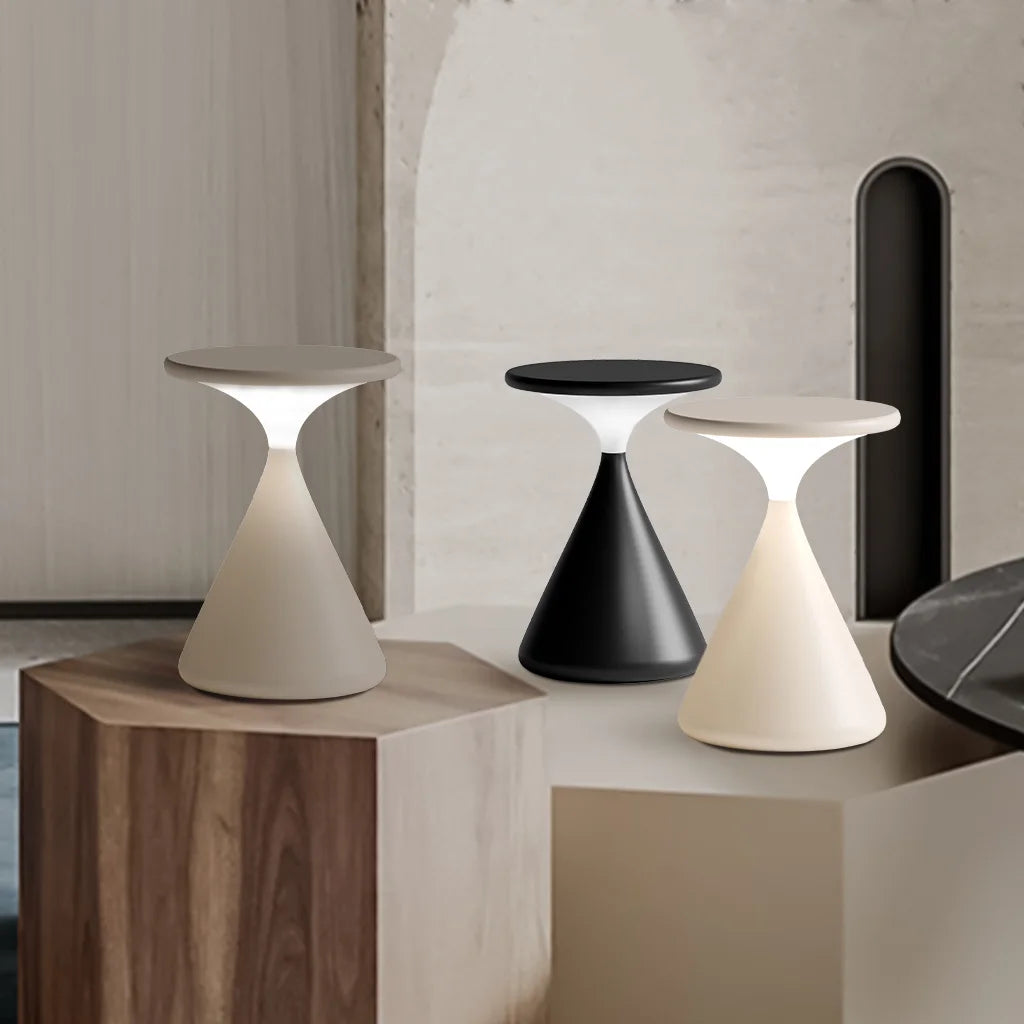Flexibel LED-lampa med timglasform placerad på en hylla i vardagsrummet.