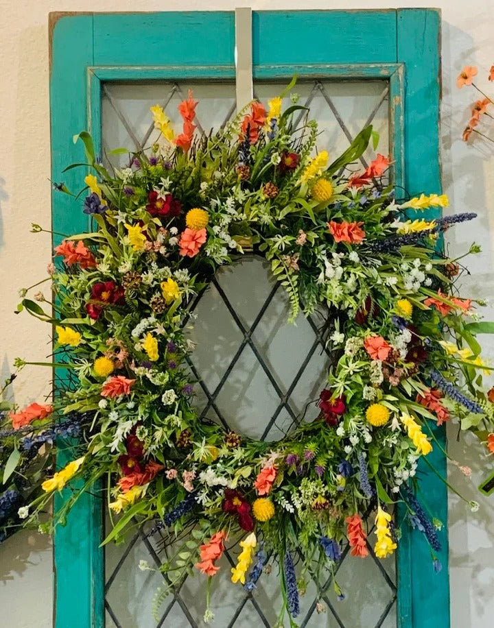 Närbild på färgstarka blommor och eukalyptusblad i kransen