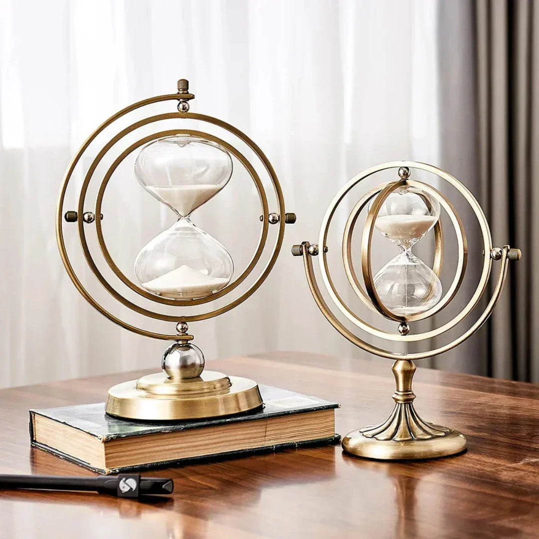 Två eleganta sandtimglas med metallram placerade på en bok