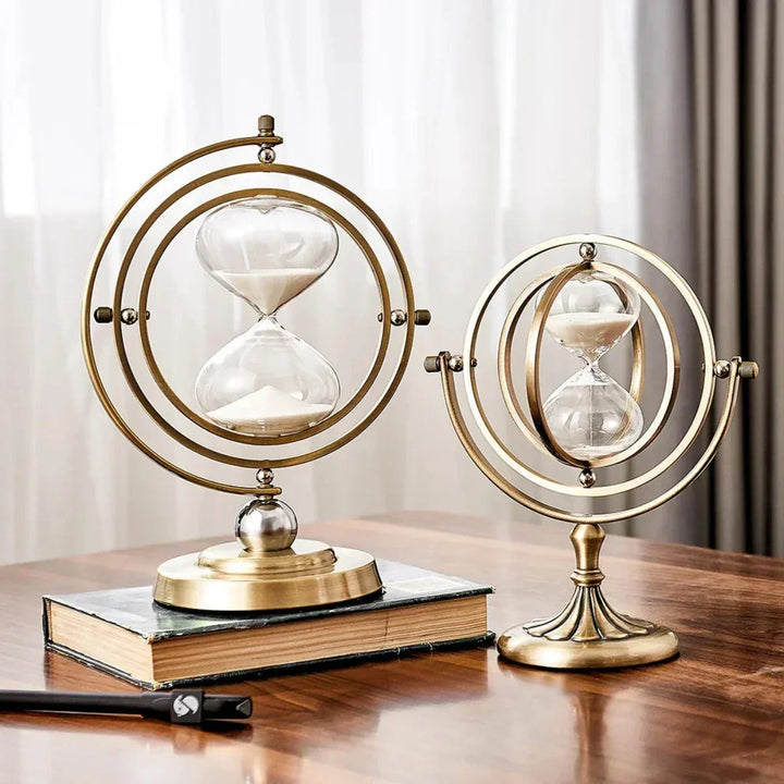 Två eleganta sandtimglas med metallram placerade på en bok
