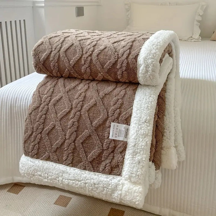 Närbild på den fluffiga sherpatexturen hos en mysig vinterfilt