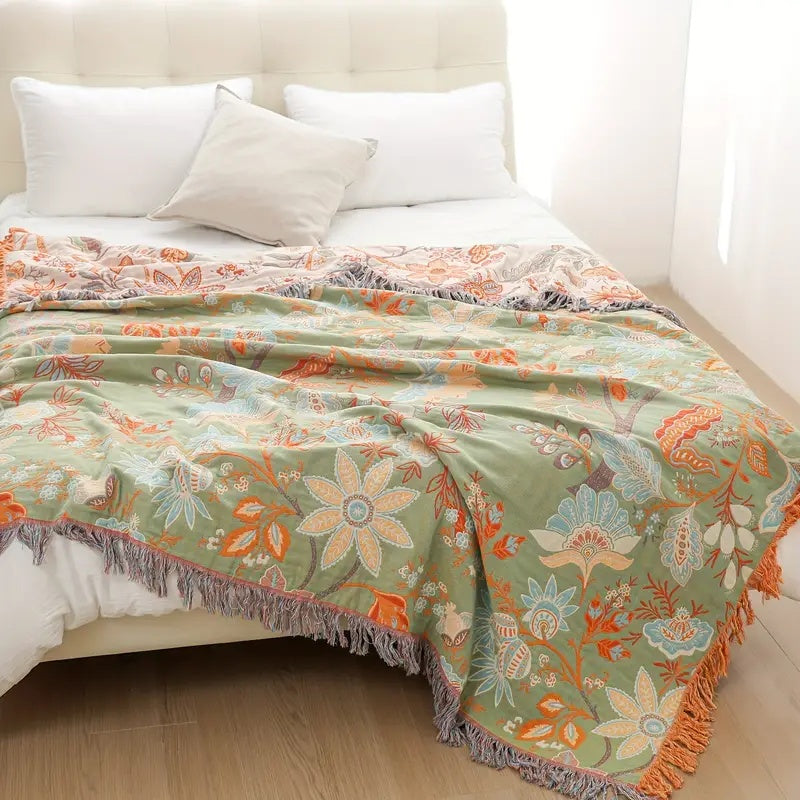 Mysig blommig filt i boho-stil vikt på soffa som snygg inredningsdetalj