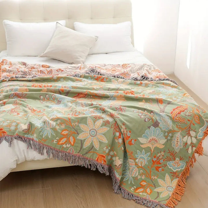 Närbild på grön blommig boho-filt med rustika designdetaljer