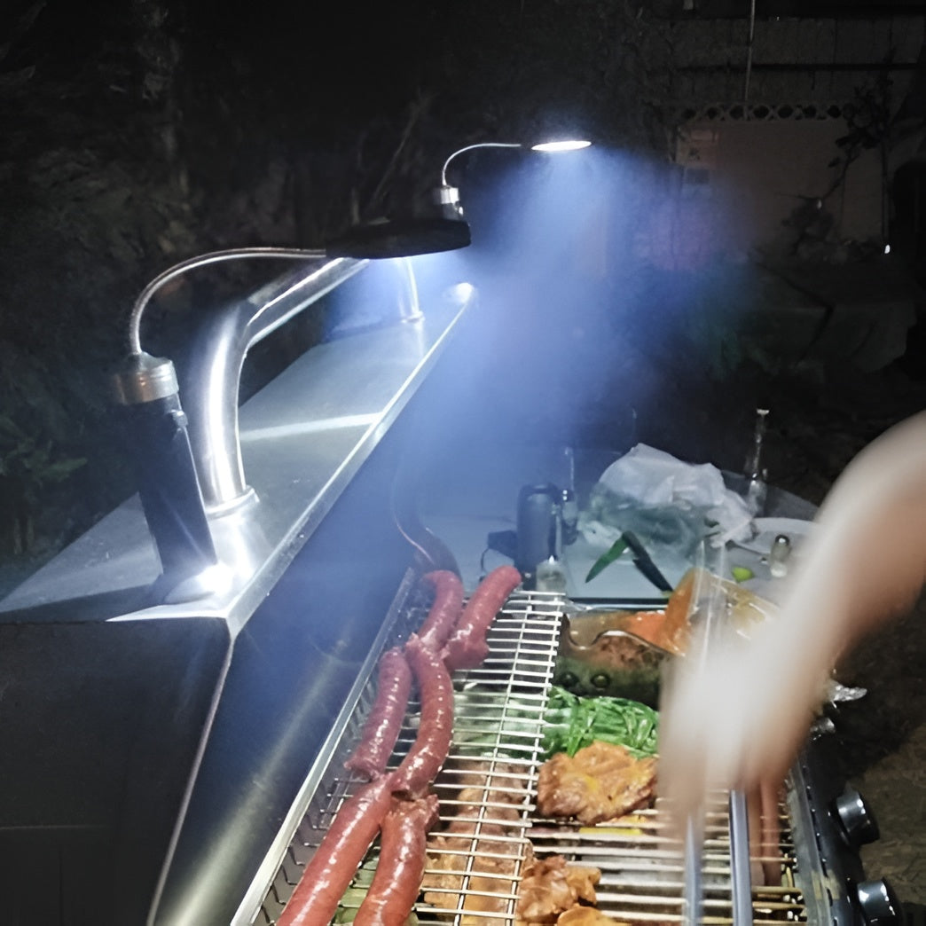 LED-grilllampa som lyser upp korvar och kött på grillgallret