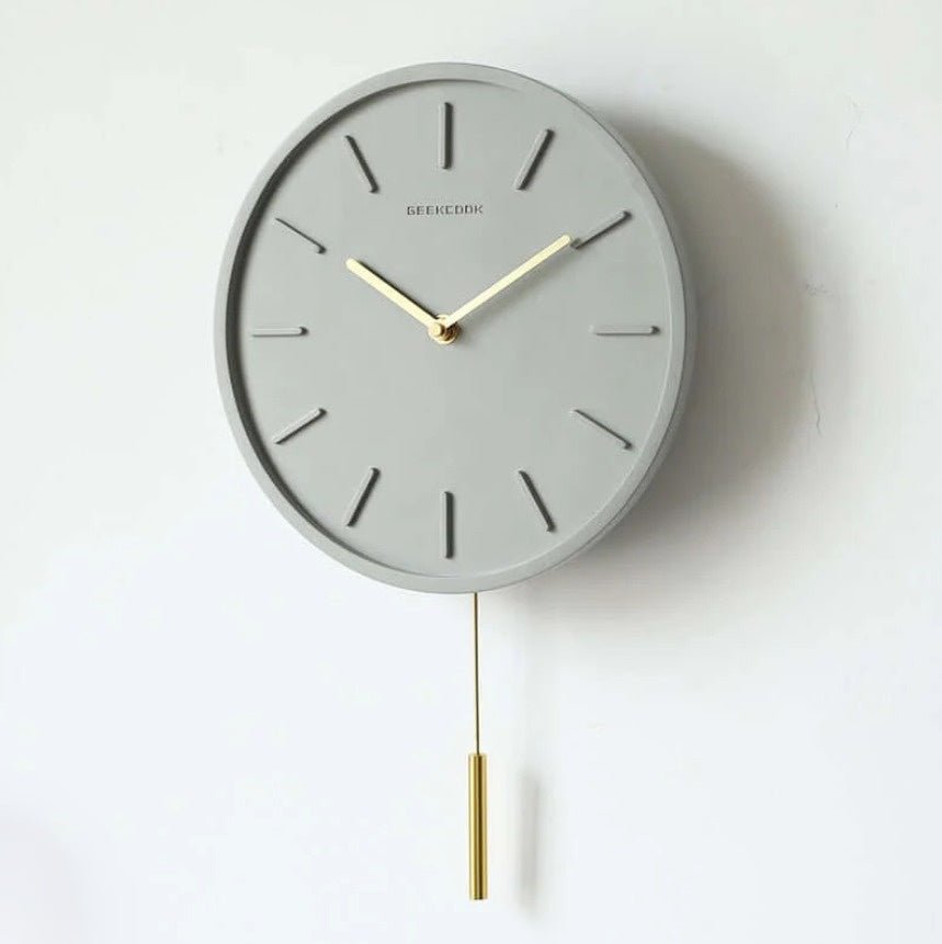 Tystgående cementklocka med industriell touch och metallpendel. Unik betongdesign för modern inredning.