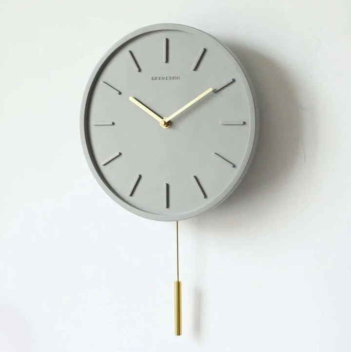 Tystgående cementklocka med industriell touch och metallpendel. Unik betongdesign för modern inredning.