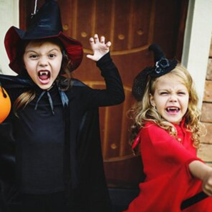 "Infällbara realistiska vampyrtänder halloween tillbehör, närbild med detaljrik ådring i vit silikon mot mörk bakgrund."