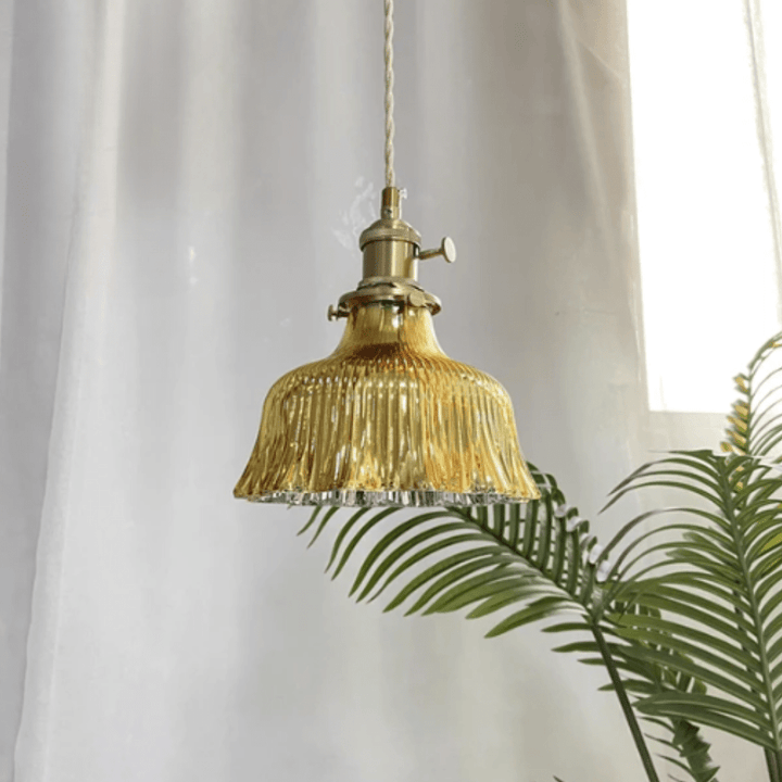 Vintage hänglampa i glas med tänd belysning som visar det varma skenet och retro designen