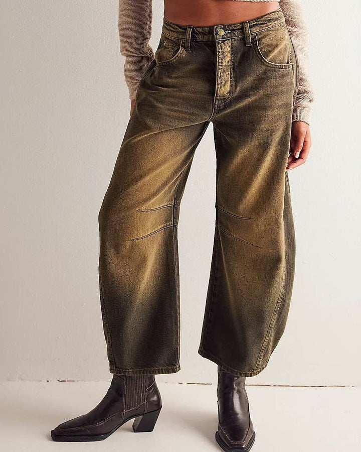 Närbild på knappknäppning och hällor i midjan på moderiktiga damjeans.