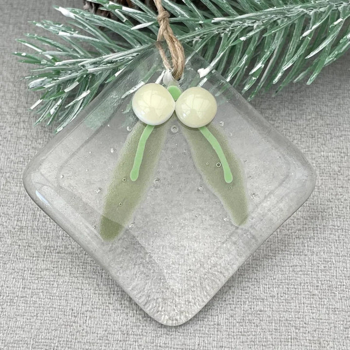 Julgransdekoration i glas med detaljerade mönster, reflekterar ljus vackert, passar för festlig julstämning.
