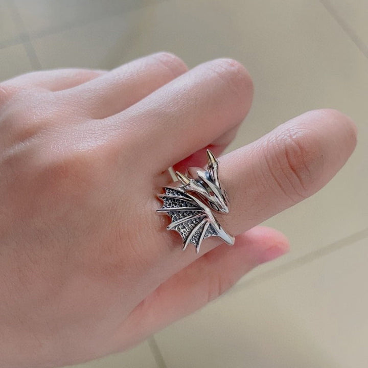 "Justerbar damring i silver med detaljrik drakdesign, symboliserar styrka och elegans, perfekt accessoar."