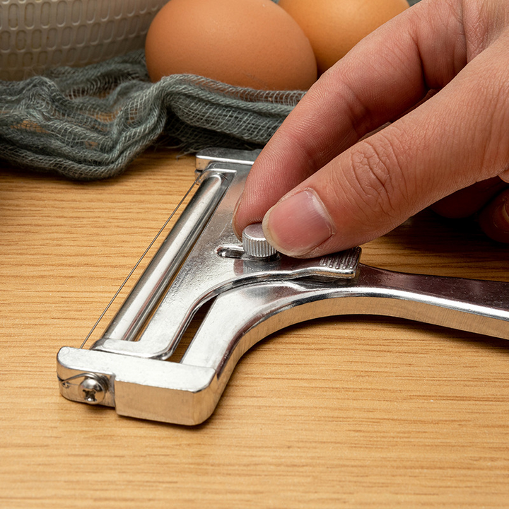 "Justerbar köksostskärare i aluminium för exakta skivor, elegant design i frostat och glänsande silver finish."