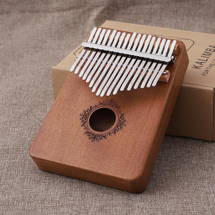 "Kalimba i mahogny med 17 metalltangenter, visad i närbild, ger melodiskt och varmt ljud, perfekt för portabelt spel."
