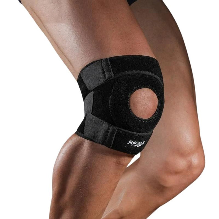 Person som bär ett svart stabiliserande knäskydd på höger ben