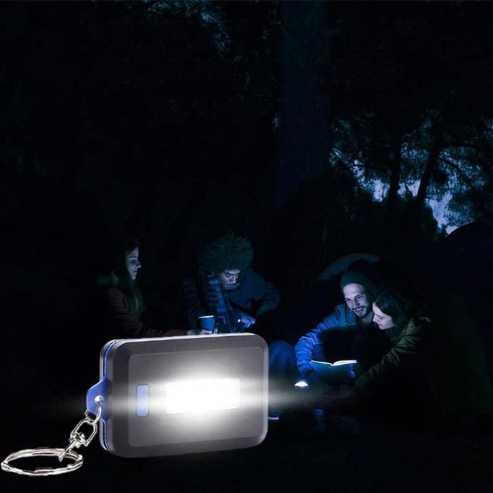 "Kompakt mini LED-ficklampa nyckelring i svart med 3 ljuslägen, perfekt för nattvandring och camping."