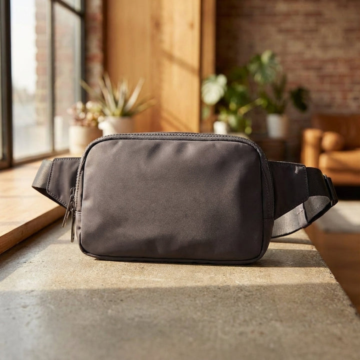 Kompakt unisex midjeväska i svart nylon. Lättviktig fanny pack för organiserad vardag & resor.