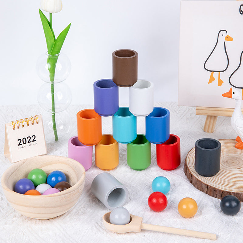 Detaljbild av färgglada bollar som placeras i matchande Montessori-koppar för barn.