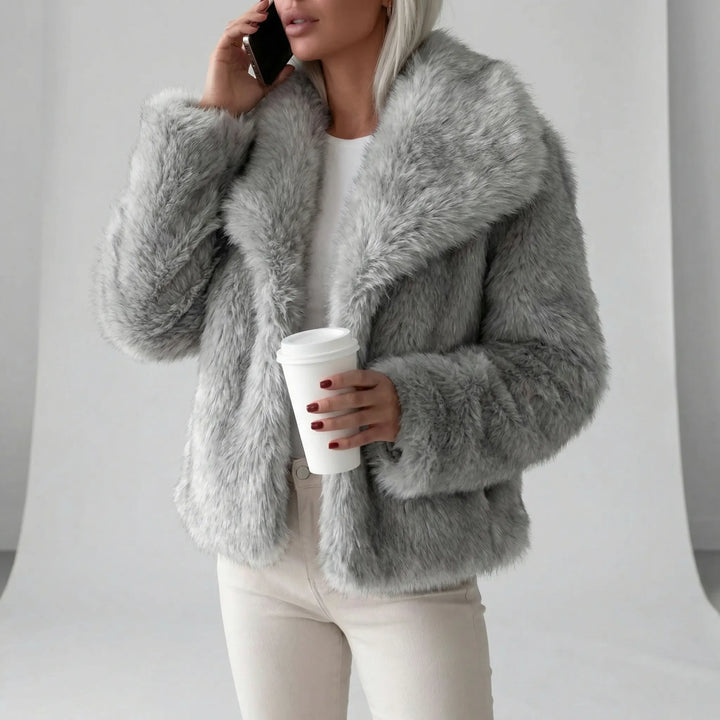 Modern kort damkappa, fluffig statementkappa i poppy-färg. Ett trendigt ytterplagg för enastående dammode.